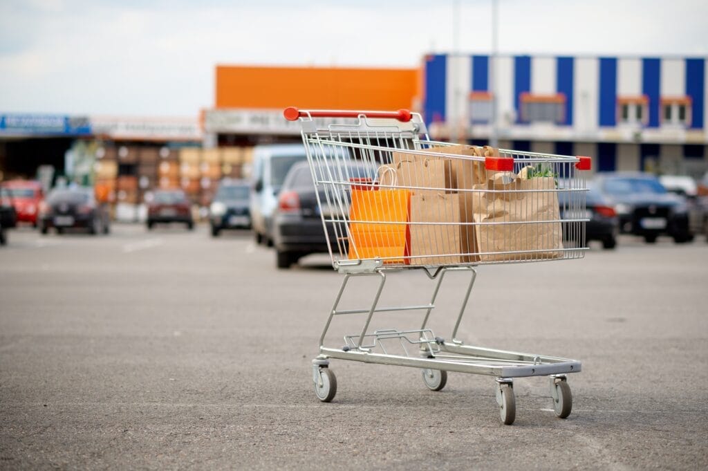 Cart with cardboard bags on supermarket parking